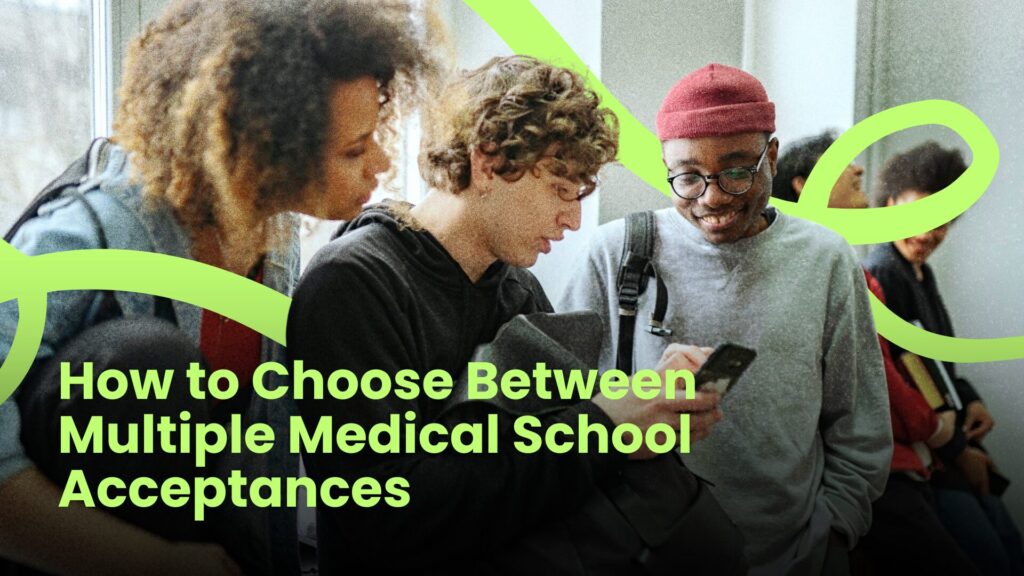 How to Choose Between Multiple Medical School Acceptances Students reviewing information on a phone while discussing how to choose between multiple medical school acceptance offers.